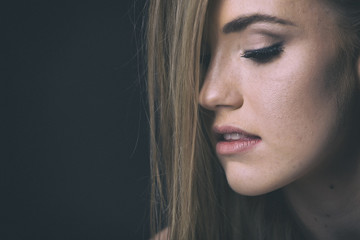 red head model with an edgy personality looking sexy in a dark studio with edgy lighting