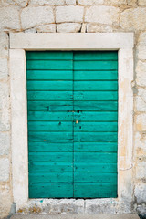 Green doors. Wood texture. Old shabby, irradiated paint. Old wooden doors