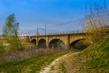 Rural Stone Road Bridge Crossing River With Beautiful Landscape, saturated photo