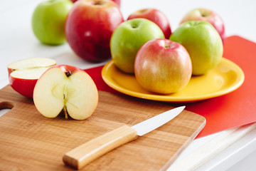 Half of an Apple and a knife on wooden surface closeup
