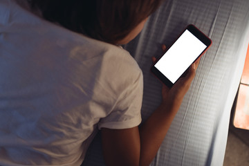 Asian women are using the smart phone on the bed before she sleeping at night. Mobile addict concept in selective focus.