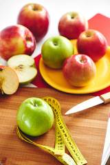 Apple and centimeter lie on a wooden plate