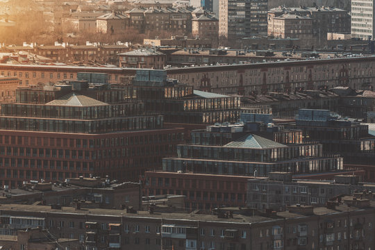 Close-up view from high point of residential district on sunny spring morning: multiple houses, two buildings with pyramidal glass roofs, multiple facades with balconies and windows, Moscow, Russia - Powered by Adobe