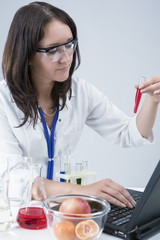 Researching Ideas and Concepts. Female Laboratory Assistant With Different Test Flasks Conducting Experiment in laboratory With Fruit Specimens.