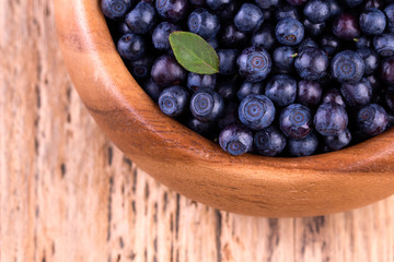 Blueberries in a bowl on a wooden table.