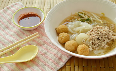 large noodles topping boiled minced pork and shrimp ball in soup with chili sauce