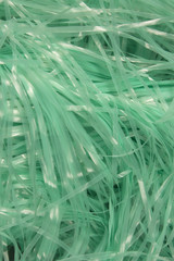 This is a photograph of Turquoise shredded plastic fake Easter grass background