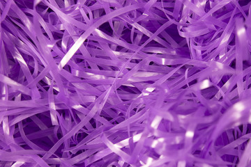 This is a photograph of Purple shredded plastic fake Easter grass background