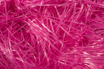 This is a photograph of Pink shredded plastic fake Easter grass background