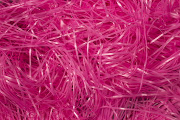 This is a photograph of Pink shredded plastic fake Easter grass background