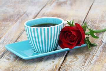 Cup of coffee with one red rose on a side with copy space
