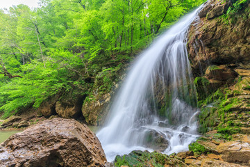 Fototapeta premium Beautiful scenic landscape of Rufabgo waterfall in green Caucasus mountain forest at springtime