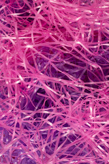 This is a photograph of Pink and Purple shredded plastic fake Easter grass background