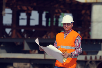 engineer in hard hat , Builder in the form of a construction drawing in the hands