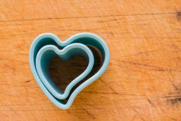 Blue star shaped plastic baking mold heart form isolated over the wooden background
