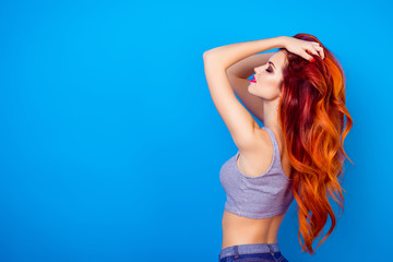 Portrait of sexual  charming stylish girl with long ginger fair hair touching head, dreaming and relaxing