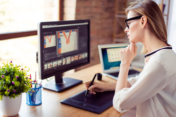 Side view of graphic designer working with interactive pen display, digital drawing tablet and pen on a computer in workstation - obrazy, fototapety, plakaty
