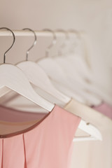 Women's clothing in pink tones on a white hanger.