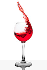 Splash of red wine in the cup filling on a white background