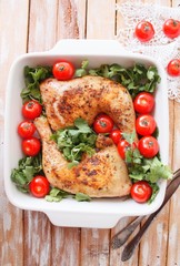Baked chicken quarter with cherry tomatoes. Roast chicken quarter with the addition of cherry tomatoes. Selective focus