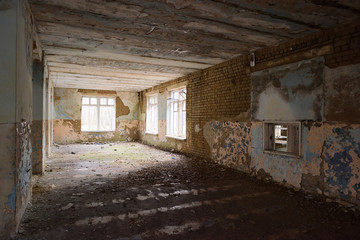 Abandoned empty shabby room with big windows
