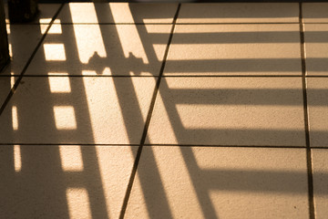 Detail Bakongeländer als Schatten auf Fliesen
