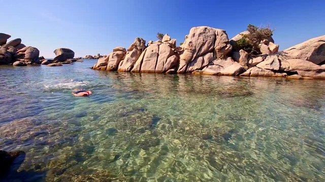 Young man snorkeling in green lagoon, Corsica France, Europe
