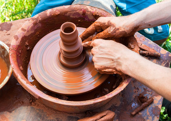Ceramics works with clay on a potter's wheel at the outdoors