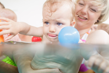 Mums and babies having fun at infant swimming course