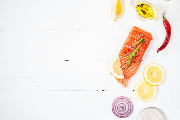 Delicious portion of fresh salmon fillet with aromatic herbs, spices and vegetables - healthy food, diet or cooking concept.