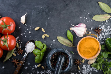 Spices and herbs  on black stone background. Top view
