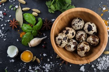  Quail eggs and spices on a dark stone background. Cooking ingredients