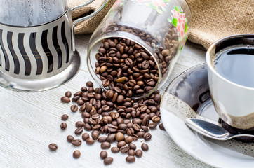coffee cup and coffee beans on white wooden table