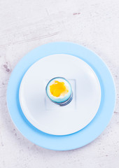 One blue easter egg with yellow yolk, top view - easter breakfast concept