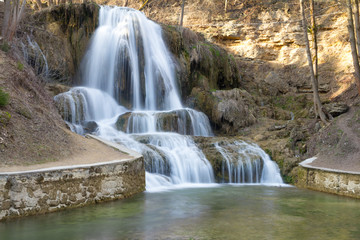 water cascading over rocks into a walled pond