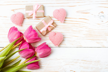 Букет тюльпанов, подарки и сердца на белом деревянном фоне