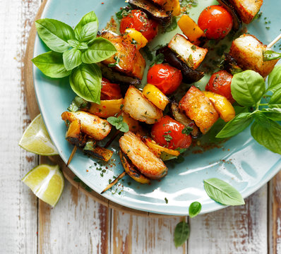 Grilled skewers of halloumi cheese and vegetables with addition aromatic herbs, top view