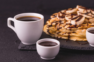 Cup of coffee and waffles with banana and chocolate