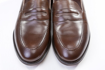 Footwear Concepts. Pair of Stylish Brown Penny Loafer Shoes Against White Background. Placed Together Closely.