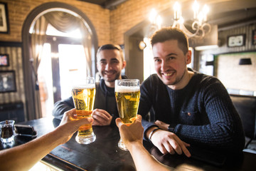 Two man in bar at counter, barman giving beer glass, friends meeting guys in pub