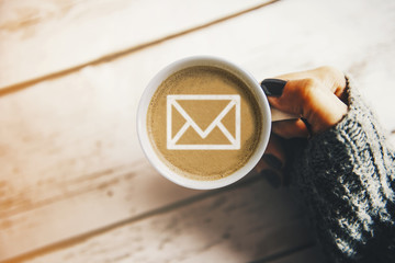 Girl with a cup of coffee with a mail symbol