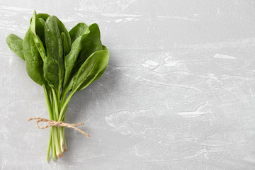 Bunch of fresh spinach leaves on stone background