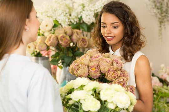 Young woman buying flowers from a florist