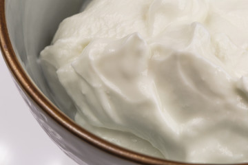 Bowl of greek yogurt isolated on white background