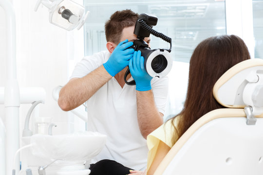 Dentist taking pictures of the teeth of his client with his camera