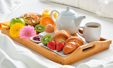 Breakfast tray in bed in hotel room