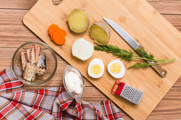 Ингредиенты для приготовления рыбного салата Мимоза на столе. Вид сверху