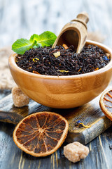 Black tea with bergamot and mint in a wooden bowl.