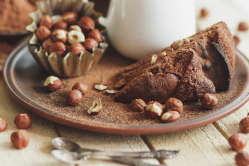 Piece of chocolate cake, hazelnuts and jar with milk