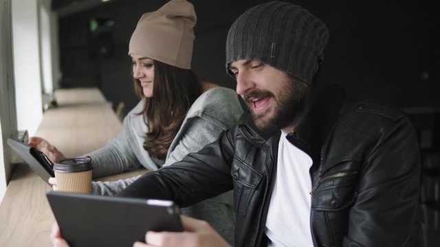 Work meeting in agency. Creative man and woman using their tablets and discuss the results of work. Shot in 4k